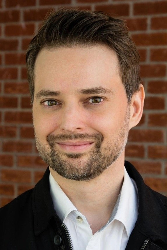 A headshot of Guy Busick.